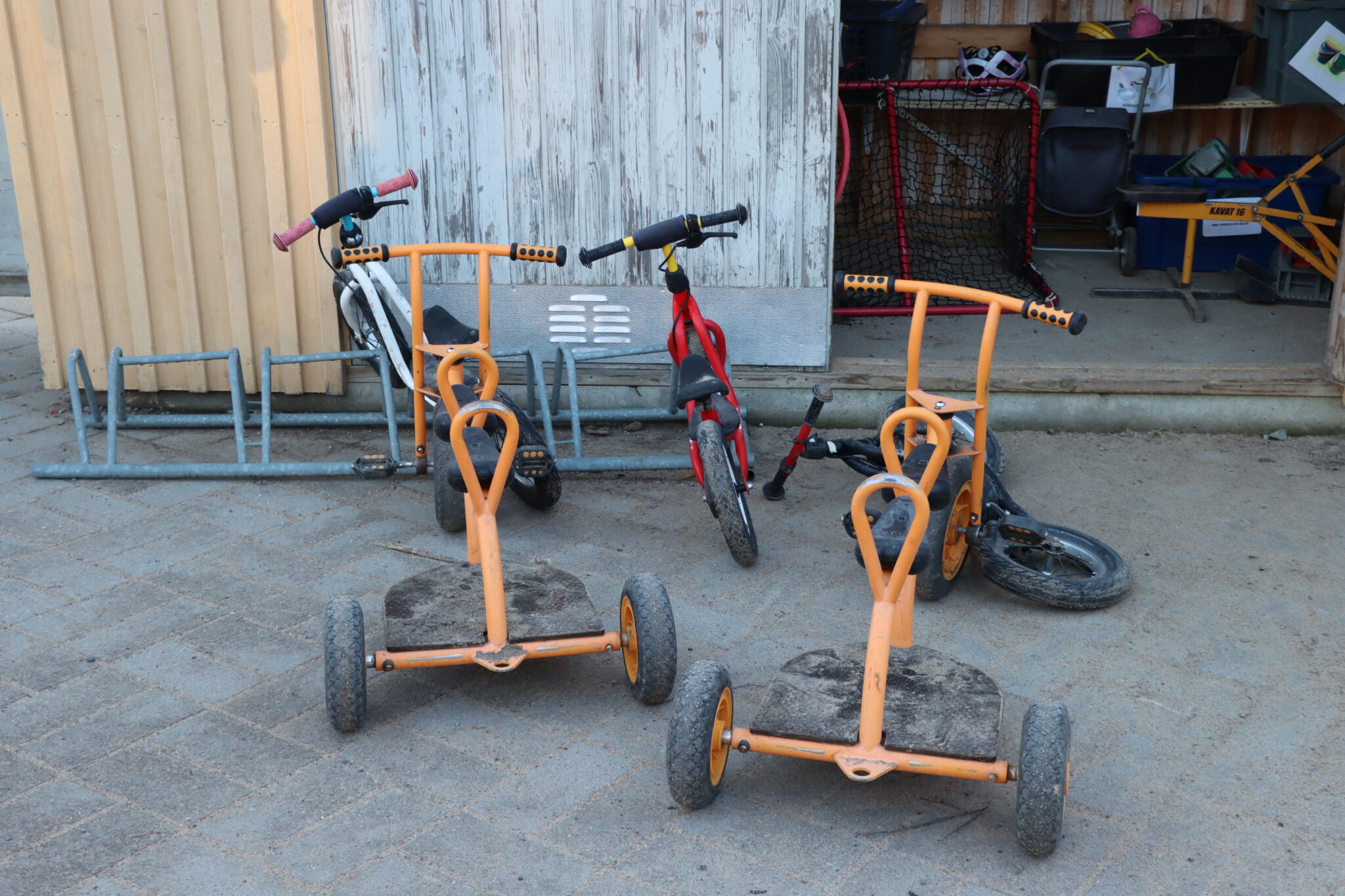 Trehjulingar och barncyklar vid ett förråd