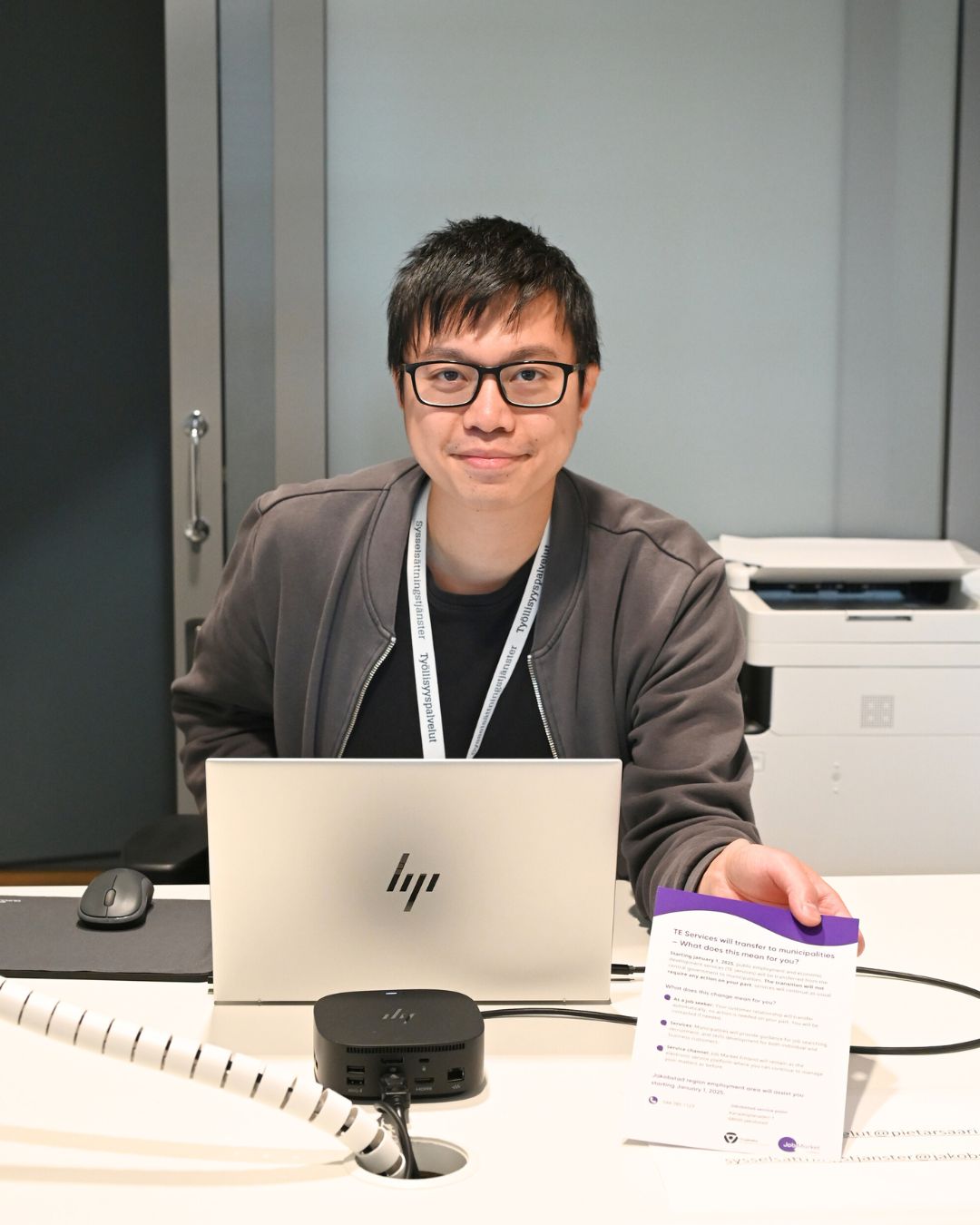 Glad person framför en laptop ger sysselsättningstjänster